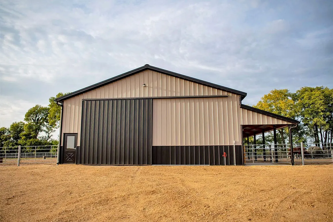 Clear-span riding arena with open sidewall and sand footing