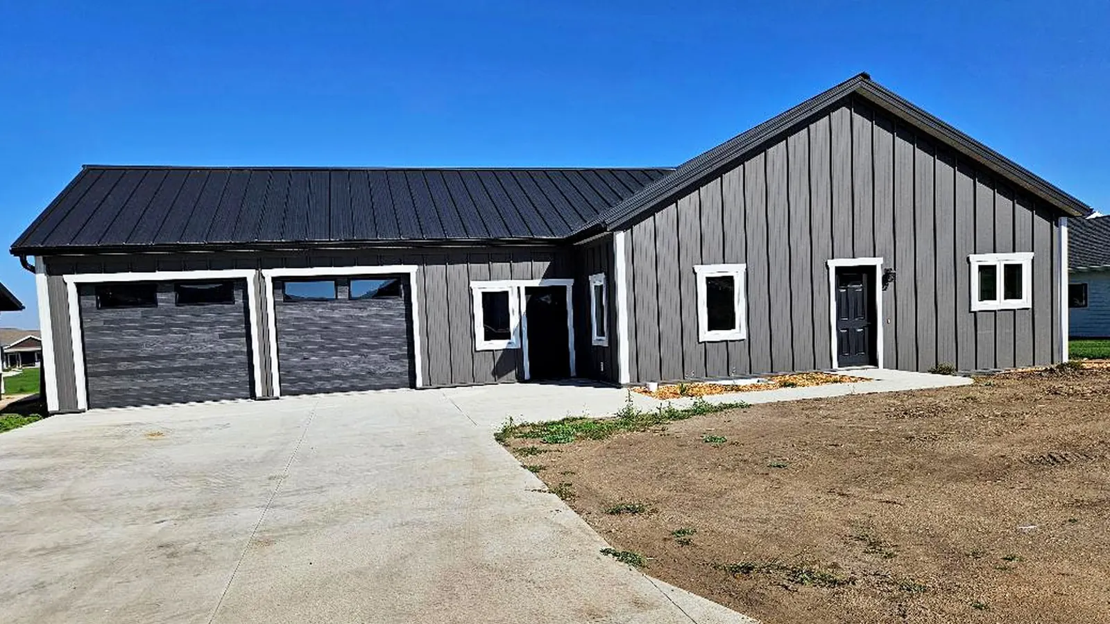 Modern dark barndominium with an attached garage