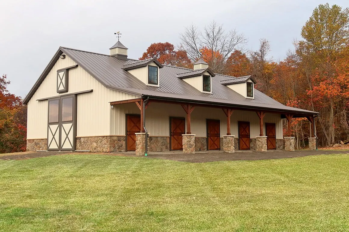 Stall barn with dormers, stone wainscot and a covered aisle